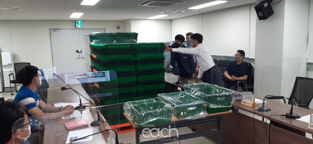 회의 중 안동광 농정해양국장이 다회성 포장재 강도를 확인하는 중 (자료제공 : 경기도)