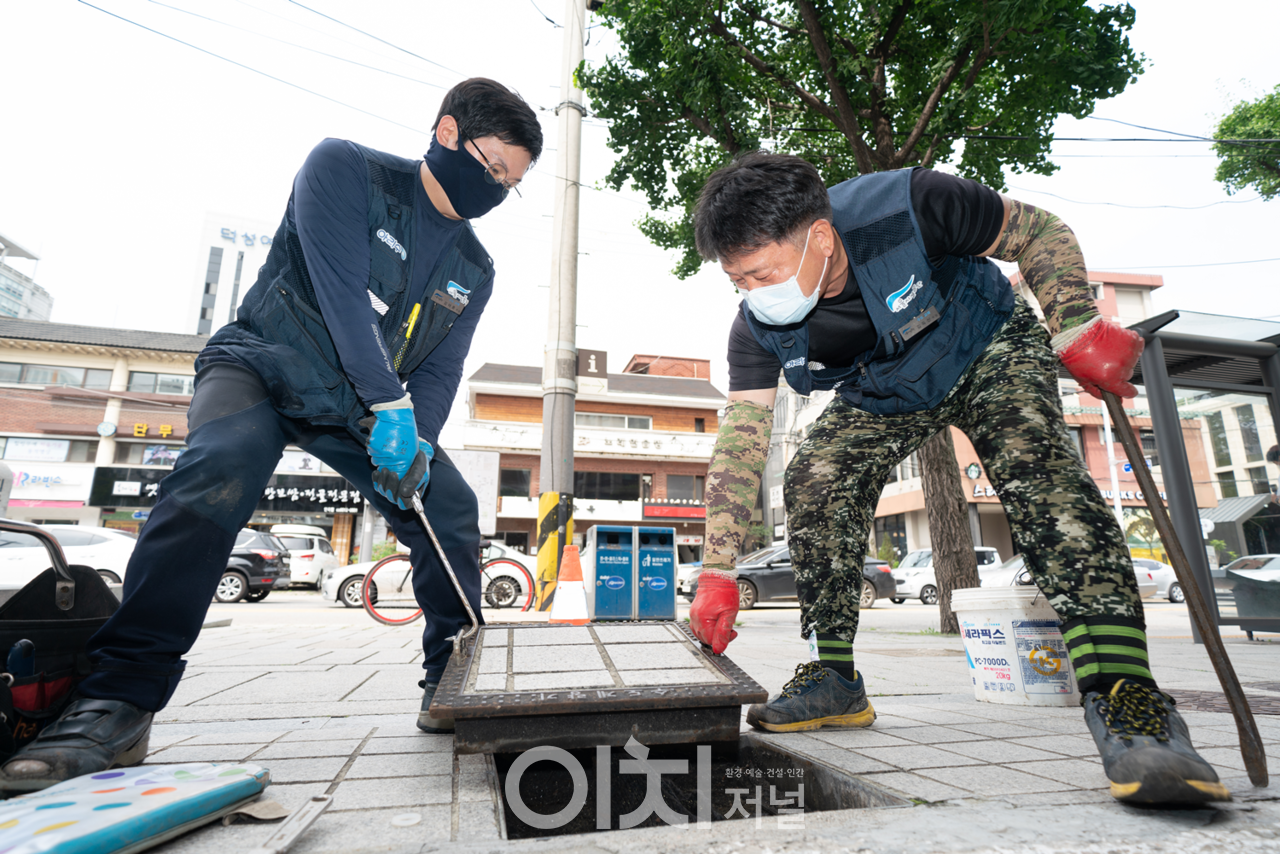 기존 보도블록 아래 설치되어 있던 수도계량기를 디지털 수도계량기로 교체하기 위해 계량기 덮개를 열고 있는 모습 (자료제공 : 서울시설공단)